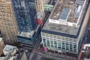 Şehir binalarının havadan görünüşü modern ve klasik mimarinin bir karışımını sergiliyor. Görüntü çatıları, sokakları ve hareketli bir şehir ortamını yakalıyor..