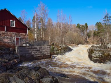 Area near Lahankoski waterfall in Finnish Pornainen: april, clear weather, river rapids, high a lot of water, nature of nordic countries.