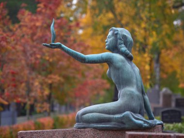 Old sculpture in European cemetery: Finland, Helsinki, Hietaniemi, autumn.