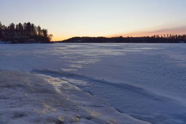 Finlandiya 'nın Tuusula Gölü' nde kışın gün batımı: Halosenniemi manzarası.