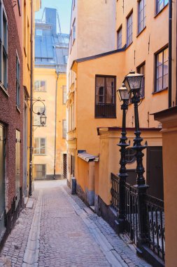 İsveç Stockholm 'ün eski bölümünün dar sokakları ve avluları: İskandinavya' nın başkenti Gamla Stan Adası 'nda güneşli Şubat turizm günü.