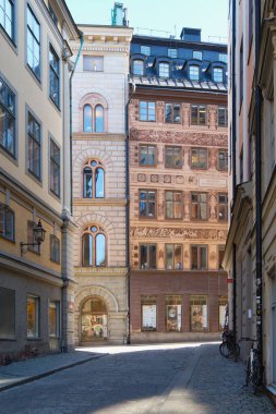 İsveç Stockholm 'ün eski bölümünün dar sokakları ve avluları: İskandinavya' nın başkenti Gamla Stan Adası 'nda güneşli Şubat turizm günü.