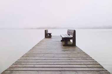 Rıhtımda karşı karşıya iki sıra ve gölde sis..