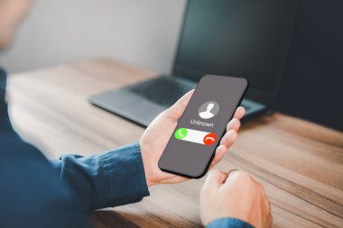 Gelen çağrıya cevap veren adam. Bilinmeyen numaradan aranmış. Çağrı merkezi çetesi, dolandırıcı ya da yabancı. Sahte kimliği olan bir sahtekar. Dolandırıcılık, dolandırıcılık veya cep telefonu veya akıllı telefon kavramı.