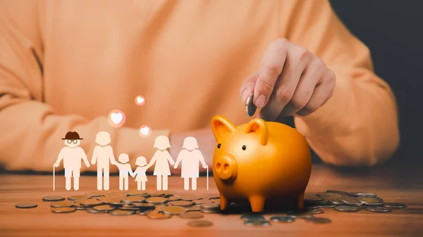 Father is head of the family, putting coins on piggy bank with family icon on the table. Concept savings money for education, travel, family financial plan, retire, financial crisis and health.