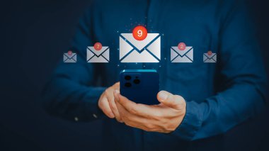 Adult man holding a mobile phone and touching with virtual screen newsletter for electronic mail or E-mail. Email marketing and newsletters, notification alert, technology and internet on smartphone.