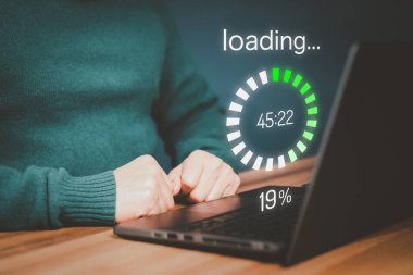Adult man using a laptop computer for download software and waiting to loading digital business data form website, very slow internet form wifi. Concept of waiting for load of loading symbol.