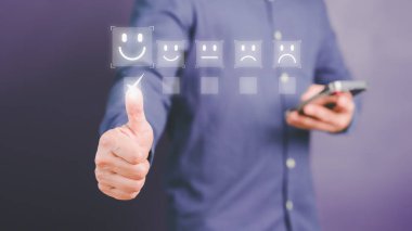 Man touching the virtual screen on the happy smiley face icon to give satisfaction in service. Rating very impressed. Assessment customer service, testimonial and satisfaction concept.