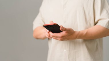 Evdeki kablosuz internete cep telefonuyla bağlanan bir adam. Erkek eller interneti taramak için algılayıcı ekranına dokunan akıllı telefon modeli tutuyor. Sanal iletişim kavramı.