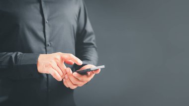 Evdeki kablosuz internete cep telefonuyla bağlanan bir adam. Erkek eller interneti taramak için algılayıcı ekranına dokunan akıllı telefon modeli tutuyor. Sanal iletişim kavramı.