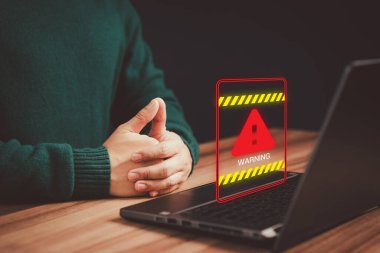 Bilgisayar virüsü teknolojisi tespit edildi, kişisel veri koruması, ağ güvenliği ve bakımı. Uyarı hatası için üçgen uyarı işareti olan bir bilgisayar dizüstü bilgisayar kullanan bir adam.
