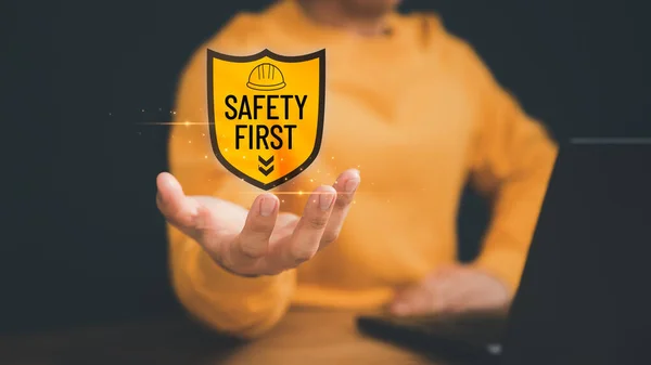 Man showing the safety banner symbol on hand. Concept of safety banner, caution work hazard, danger surveillance, safety first symbol, work safety, zero accident, worker safety awareness at workplace.