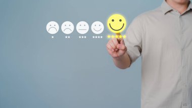 Değerlendirme tanımı müşteri hizmetleri ve geri bildirim, görüş derecesi çok etkilenmiş bir kavram. Müşteri eli, hizmet memnuniyeti vermek için gülen yüz simgesinin sanal ekranına dokunuyor..