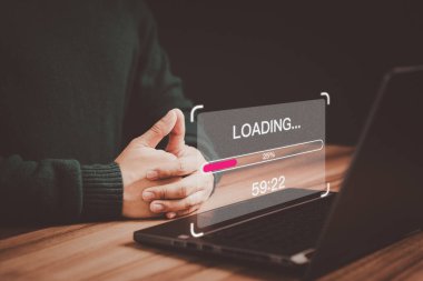 Genç kullanıcı yazılım indirmek ve güncellemek için bir dizüstü bilgisayar kullanıyor ve dijital dosya veri formu web sitesi yüklemeyi bekliyor, çok yavaş bir internet formu wifi. Yükleme simgesinin yüklenmesini bekleme kavramı.