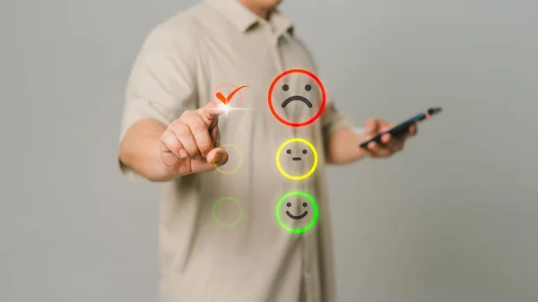 Client hand is touching virtual screen on the angry emotion face. Assessment testimonial review for dislike service and low quality. Business service concept of customer experience dissatisfaction.