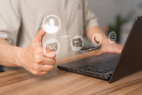 User use a laptop with a virtual screen for apps phones, email, addresses, chat, and message icons. The customer service support hotline contacts us with the people connection technology concept.