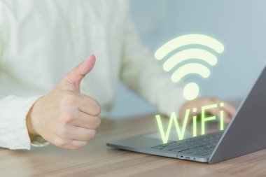 Genç adam kafedeki bilgisayarında kablosuz internet arıyor ve bağlantı kuruyor. Teknolojik bağlantı kavramı ve bilgisayar ile kablosuz bağlantı sorunları.