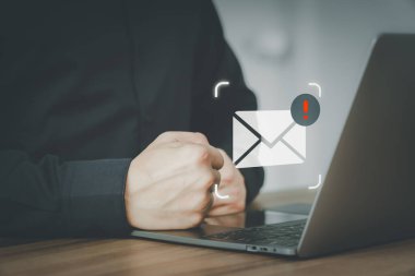 E- posta simgesi olan bir bilgisayar dizüstü bilgisayar kullanan erkek, uyarı işareti olan bir e-posta uyarısı yapan bir uyarı hatası. İnternetteki güvenlik koruması, gereksiz postalar ve gizli bilgiler..