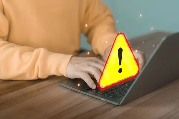 User man using a computer laptop with triangle caution warning sign for notification error. Concept technology of computer virus detected, personal data protection, network security and maintenance.