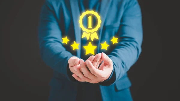 Businessman hand show the best quality assurance with golden warranty symbol. Assessment quality assurance of business services. Guarantee, warranty, standard, ISO certification, testimonial concept.