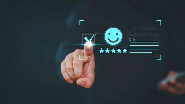 User hand touch virtual screen on smile face icon to give satisfaction in opinion on online application. Customer satisfaction survey, service experience rating, testimonial, feedback and review.