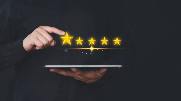Hand using a tablet give point five stars icon for feedback review satisfaction service opinion and testimonial. Customer service experience assessment and business satisfaction survey.