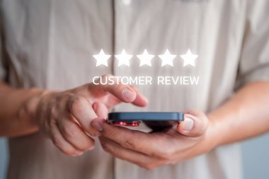 Akıllı telefon kullanan müşteri, geri bildirim değerlendirmesi memnuniyet hizmeti görüşü ve referans için nokta beş yıldız simgesi verdi