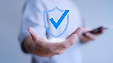 Kullanıcı eli sanal ekranda güvenlik koruma sistemi için garantili kimlik simgesini gösterir. Onaylı garanti ya da güvenli erişim sistemi konsepti. İş hizmetlerinin kalite güvencesi.