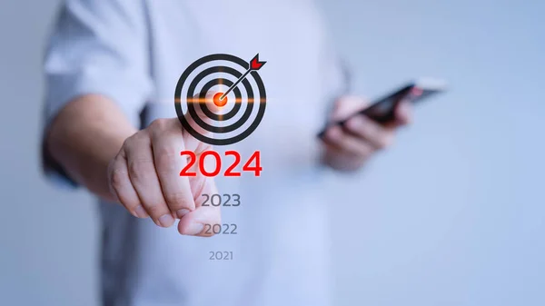 Male hand touching the goal icon from 2021 to 2024 for goal, good health, start up, life balance, plan, learning in new business.
