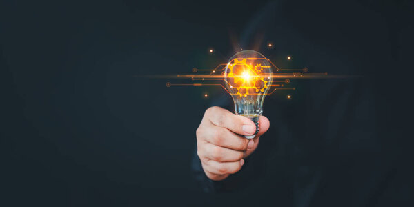Male hand holding illuminated light bulb. Creative idea, new business plan, motivation, innovation, inspiration. Energy saving light bulb. Concept of new ideas with innovation and creativity.