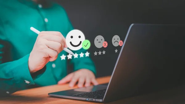 Customer use laptop with virtual screen on happy smile face icon for assessment feedback review satisfaction opinion and testimonial. Customer service experience and business satisfaction survey.