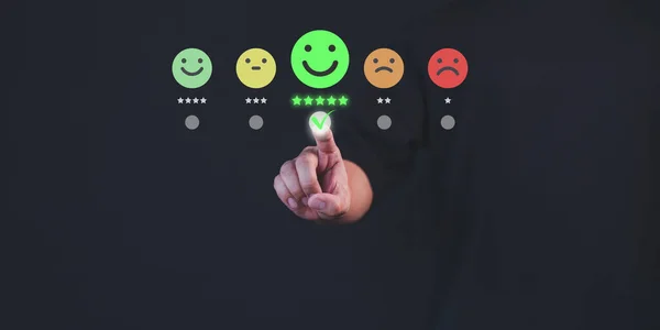 Customer hand touch virtual screen on happy smile face icon to give satisfaction in service. Online review concept of assessment testimonial customer service and feedback, Opinion rating very good.