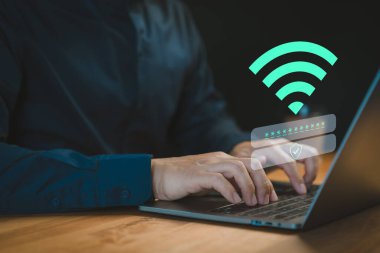 Kullanıcı, bir Wi-Fi bağlantısı kullanarak bir dizüstü bilgisayara giriş yapar, bir kullanıcı adı ve şifre girerek. Teknoloji kavramı internet erişimini, çevrimiçi güvenliği ve kişisel veri korumasını vurguluyor.