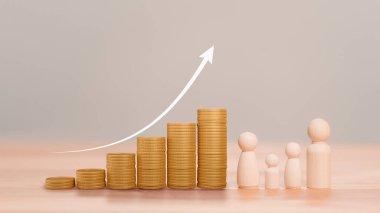Altın para yığınları, finansal büyümeyi ve zenginliği sembolize ediyor, yukarı bakan bir okla. Tahta insan figürleri madeni paraların yanında duruyor. Aileyi ve nesilsel zenginliği temsil ediyor..
