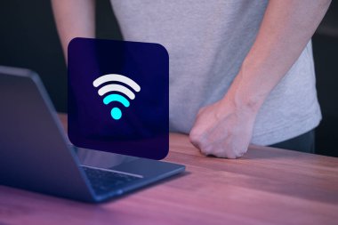 Erkek kullanıcı dizüstü bilgisayarını kablosuz internete bağlıyor, ama kablosuz bağlantı için beklemede konsept teknolojisi çok zayıf..