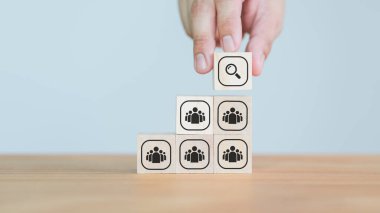 İnsanların üzerine bir büyüteç simgesi yerleştirmek ahşap bloklar oluşturmak, yetenek aramasını, şirketini, liderliğini, asker alımını ya da liderlik stratejisini temsil etmek..
