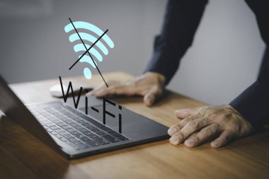 Wi-Fi 'ye bağlanmak için dizüstü bilgisayar kullanan erkek kullanıcı, internet bağlantı sorunlarını, ağ arızasını, çevrimdışı modu veya teknoloji bozulmasını temsil ediyor.