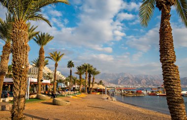 Morning on sandy beach of the Red Sea in Eilat - famous tourist resort and recreational city in Israel. Concept of bliss vacation and happy holiday  