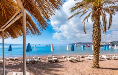 Morning on sandy beach of the Red Sea in Eilat - famous tourist resort and recreational city in Israel. Concept of bliss vacation and happy holiday  