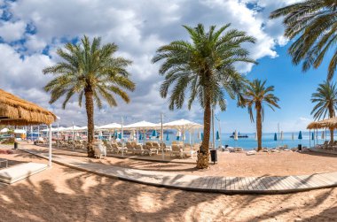 Eilat 'taki Kızıldeniz' in merkez halk plajında sabah - İsrail 'in ünlü turistik beldesi ve eğlence şehri. Mutlu tatil kavramı ve mutlu tatil.  