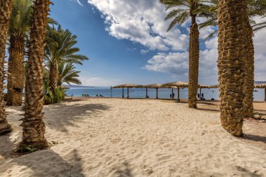 Morning on sandy beach of the Red Sea in Eilat - famous tourist resort and recreational city in Israel. Concept of bliss vacation and happy holiday  
