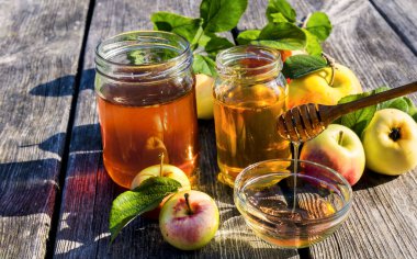 Musevi Yeni Yıl tatili 'nin ana sembolleri olan tatlı bal ve elma kavanozlarıyla kapatın. Şenlikli yemek özellikleri ahşap masa üzerinedir.