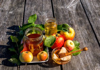 Kavanozlar dolusu tatlı bal ve elmayla kapatıyoruz. Yeni yıl Yahudi bayramının ana sembolleri. Rosh ha - Shanah. Şenlikli yemek özellikleri ahşap masa üzerinedir.. 