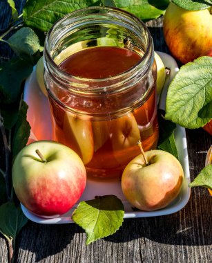 Kavanozlar dolusu tatlı bal ve elmayla kapatıyoruz. Yeni yıl Yahudi bayramının ana sembolleri. Rosh ha - Shanah. Şenlikli yemek özellikleri ahşap masa üzerinedir.