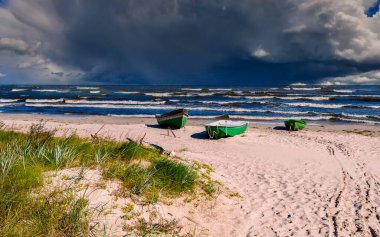 Sonbaharda kıyı manzarası. Baltık Denizi 'nin kumlu sahillerine demir atmış balıkçı tekneleri.