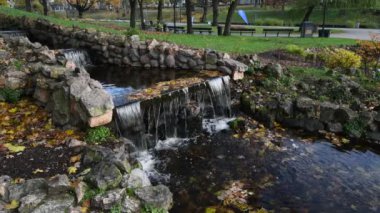 Altın sonbahar mevsiminde eski halk parkında küçük dekoratif çağlayanlar.