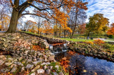 Altın sonbahar mevsiminde eski halk parkında küçük dekoratif çağlayanlar.