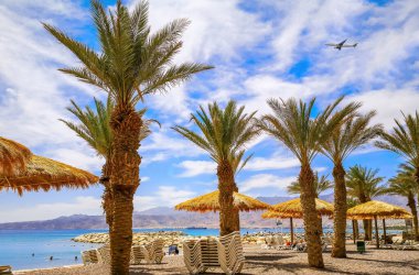 Morning on sandy beach of the Red Sea in Eilat - famous tourist resort and recreational city in Israel. Concept of bliss vacation and happy holiday  