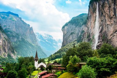 İsviçre 'nin İsviçre Alpleri' ndeki kanyon, kilise ve ünlü Staubbach şelalesiyle Lauterbrunnen 'deki inanılmaz manzara. İnanılmaz yerler..