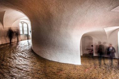 Silhouettes of people in spiral wide corridor in Round Tower or Rundetaarn in Copenhagen, Denmark. clipart